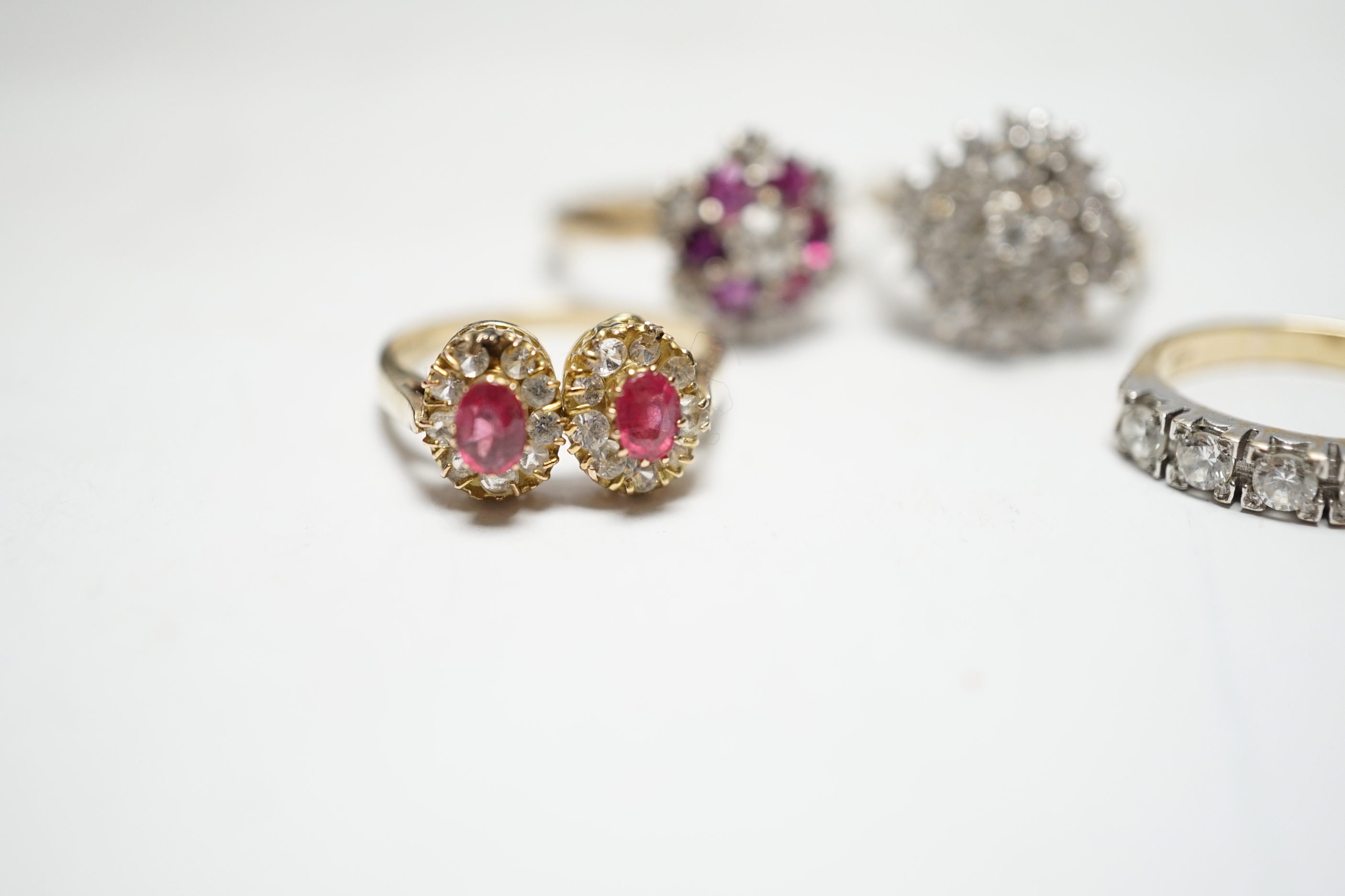 A modern 9ct gold, ruby and simulated diamond cluster set flower head ring, size N and three other assorted 9ct rings including CZ and two colour paste, gross weight 12.4 grams.